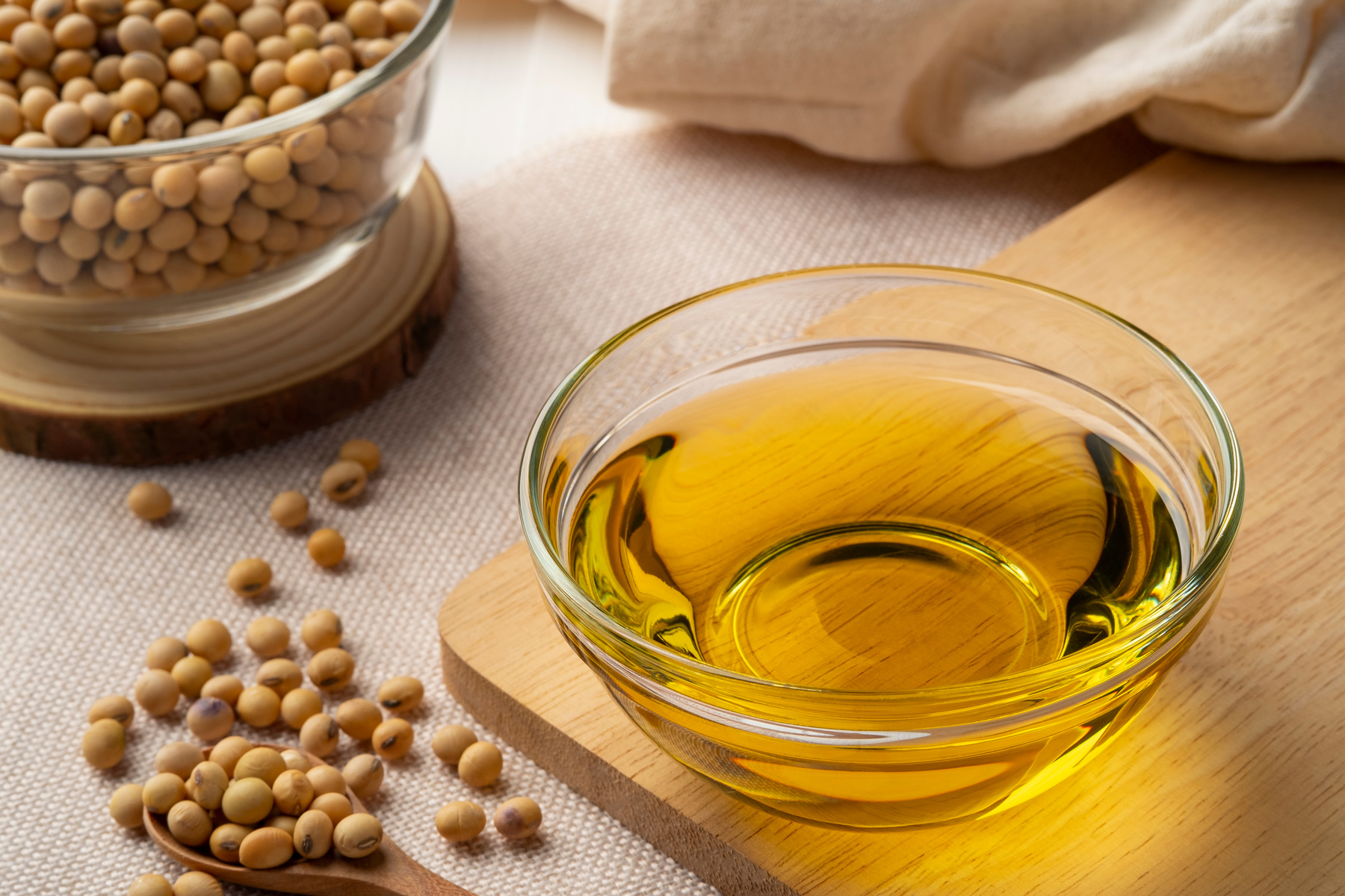 Soybean oil,is a vegetable oil extracted from the seeds of the soybean,in glass bowl on wooden table