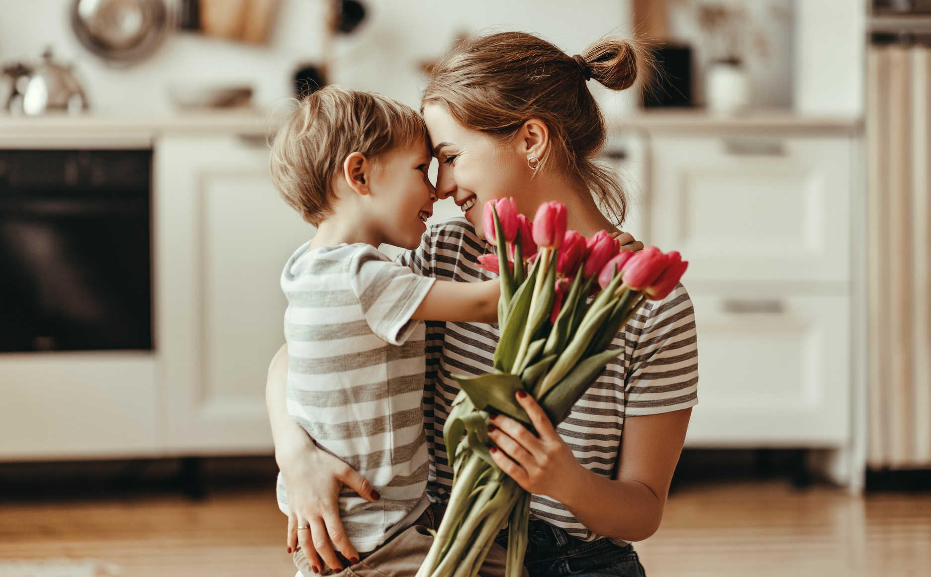 happy mother's day! child son gives flowers for mother on holiday